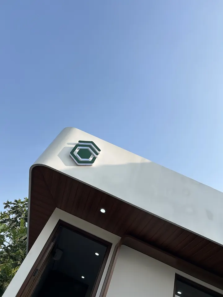 The curved white roofline and green Gimbo logo against a clear blue sky.