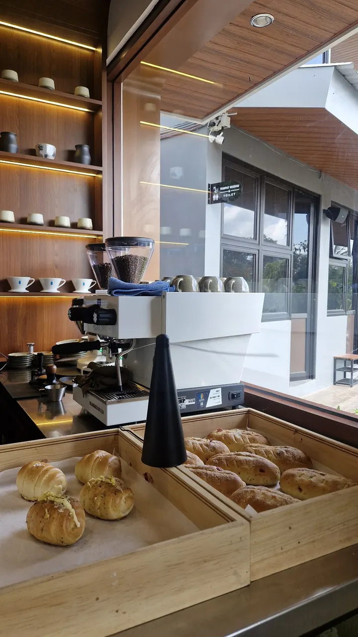Wooden trays of freshly baked breads and croissants at the counter.